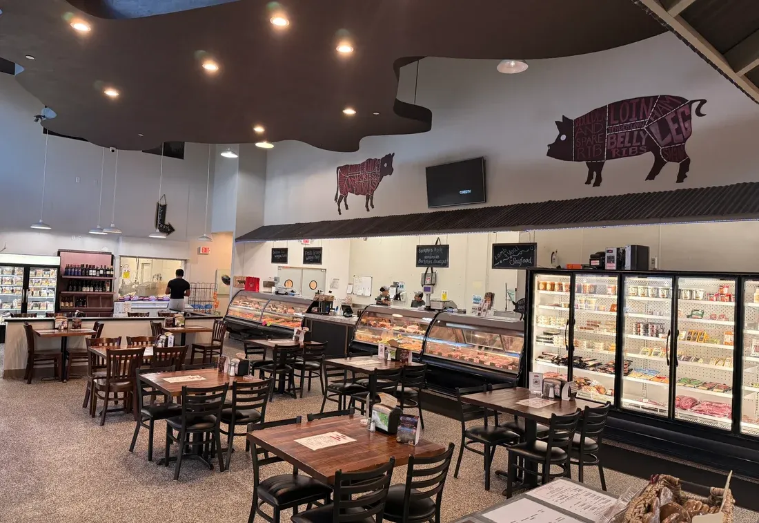 Inside Jimmy P's Butcher Shop & Cafe in Bonita Springs — butcher cases, café tables, and a bright shop floor
