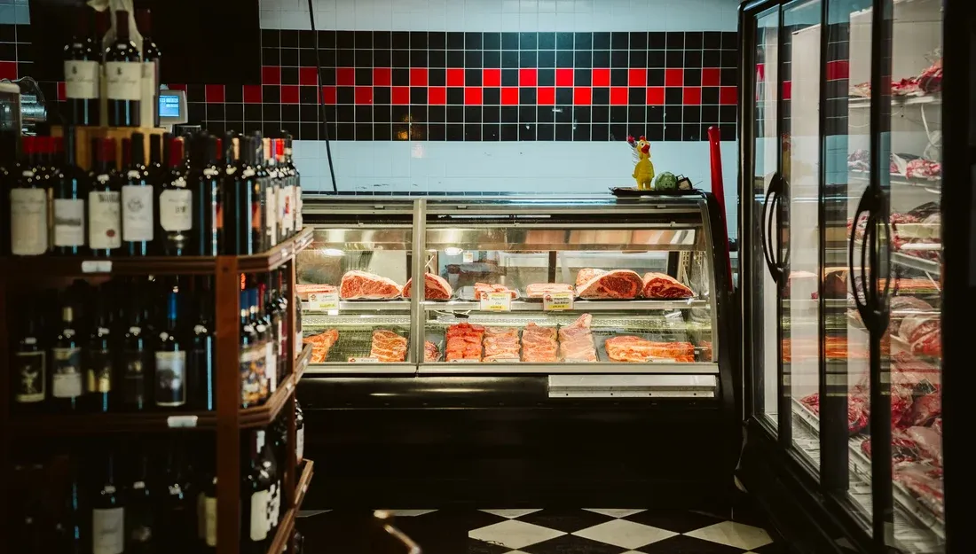 Jimmy P's Naples butcher case with premium cuts and a wall of wine