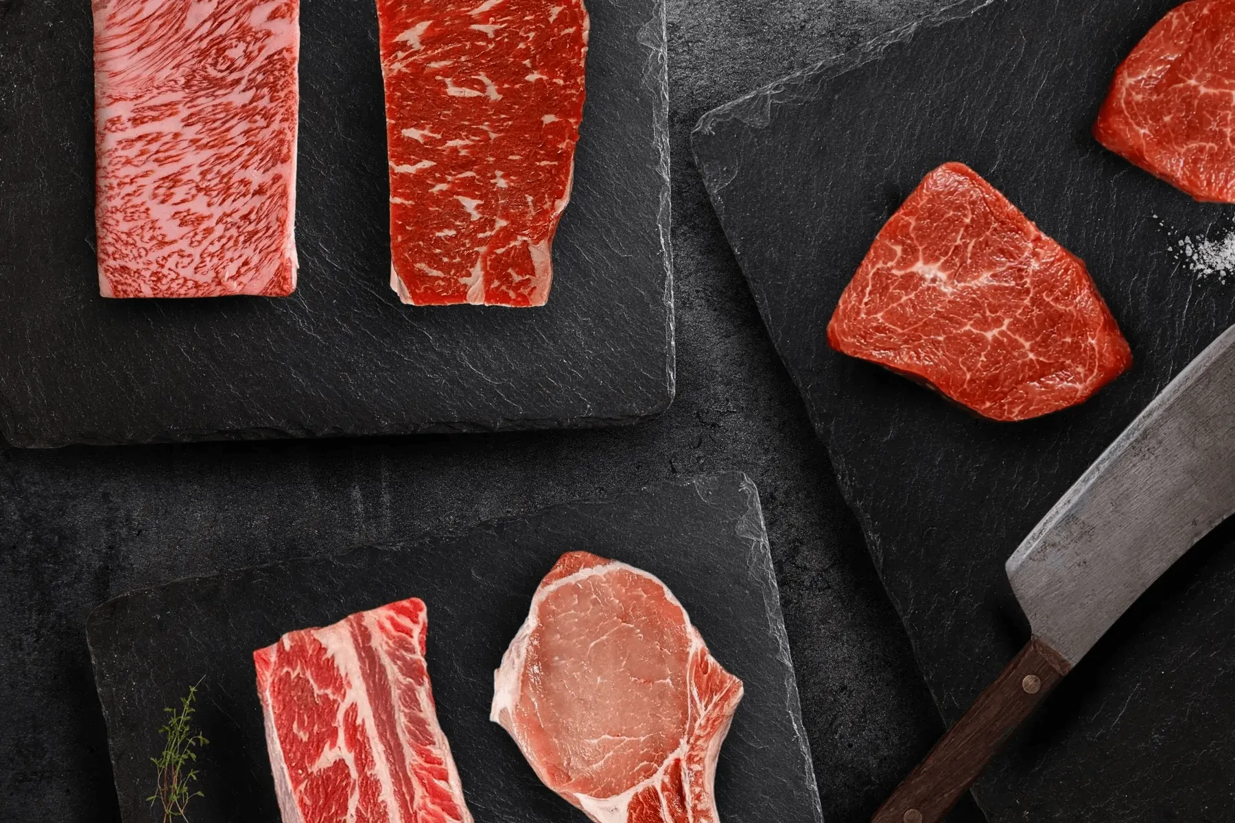 Premium beef cuts arranged on dark slate — the Jimmy P's standard